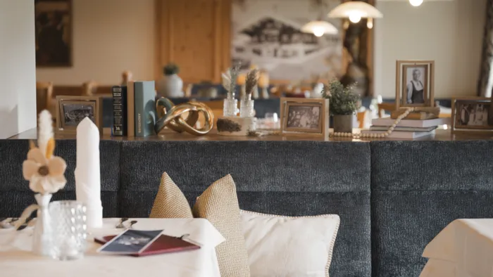 Gemütliches Restaurantinterior mit Dekor, gerahmten Fotos und gedecktem Tisch