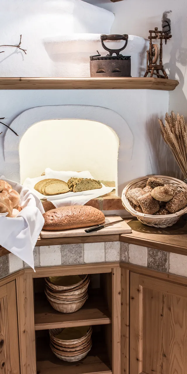 Rustikales Frühstücksbuffet mit frischen Brötchen, Müsli und beschrifteten Marmeladengläsern