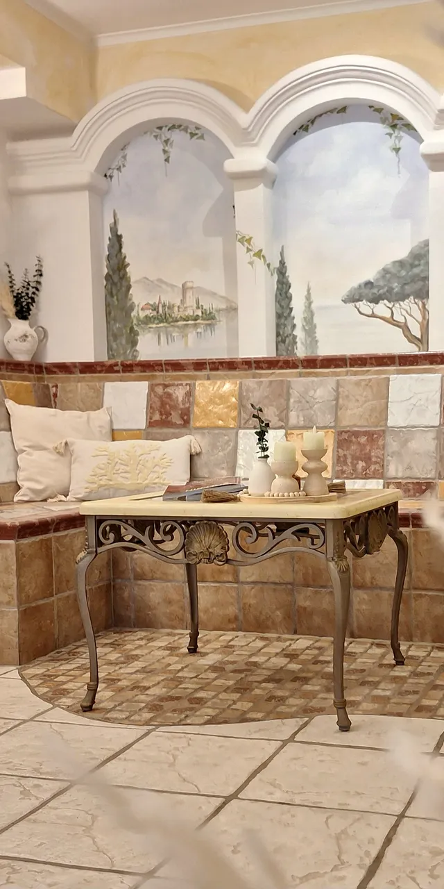 Cozy tiled seating area with decorative pillows and wall art in warm tones