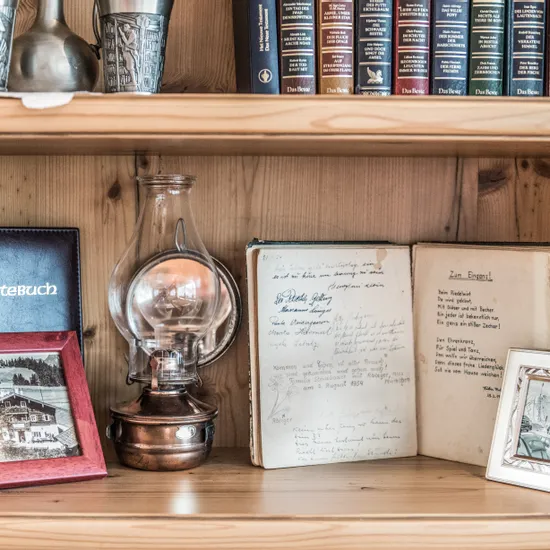Bookshelf with vintage oil lamp, guest book, old photos, and antique handwritten journal