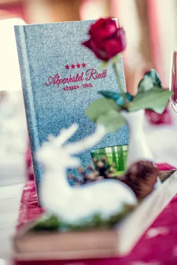 Alpenhotel Riedl menu with red rose and festive table decoration in Kössen, Tirol
