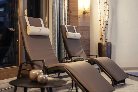 Zwei moderne Spa-Liegestühle mit Kissen im gemütlichen Innenbereich des Wellnessbereichs