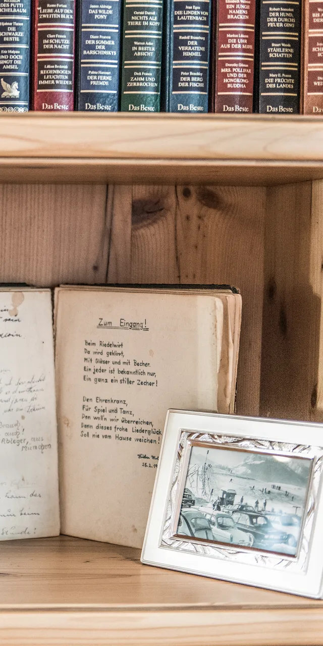 Bücherregal mit antiker Öllampe, Gästebuch, alten Fotos und handgeschriebenem Tagebuch