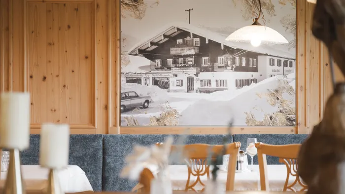 Rustic restaurant interior with wooden walls and vintage chalet mural