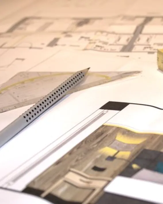 Architektonische Grundrisse mit Maßstab, Geodreieck und Stift auf dem Zeichentisch