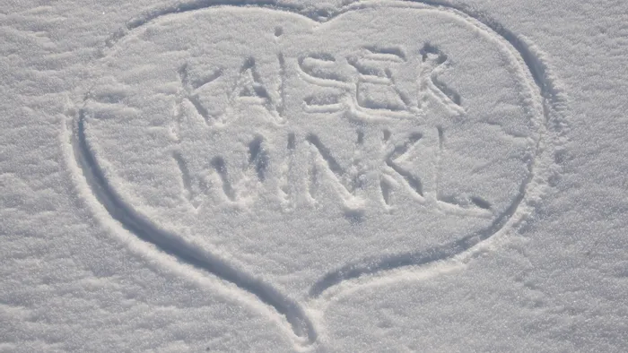 Heart shape with Kaiserwinkl written in snow on a winter landscape