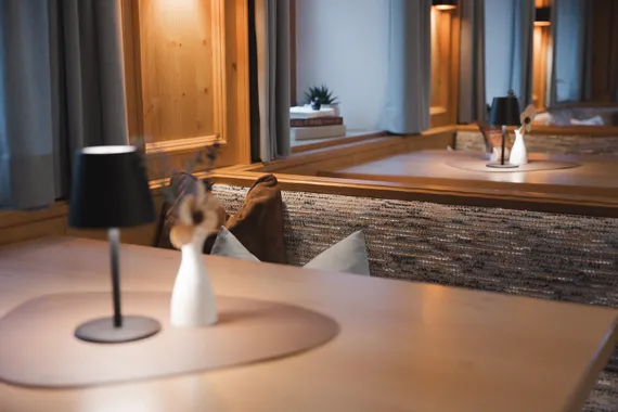 Moderne gemütliche Essecke mit Holzeinrichtung, schwarzer Lampe und Dekovase