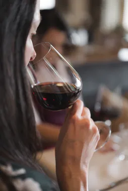 Person smelling red wine in a glass during a tasting