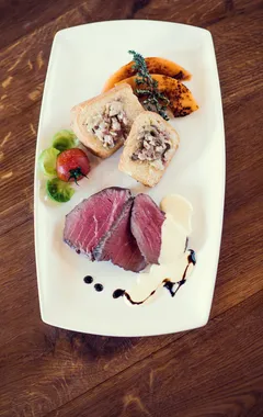 Gourmet beef slices with white sauce, toast with topping, roasted squash and vegetables