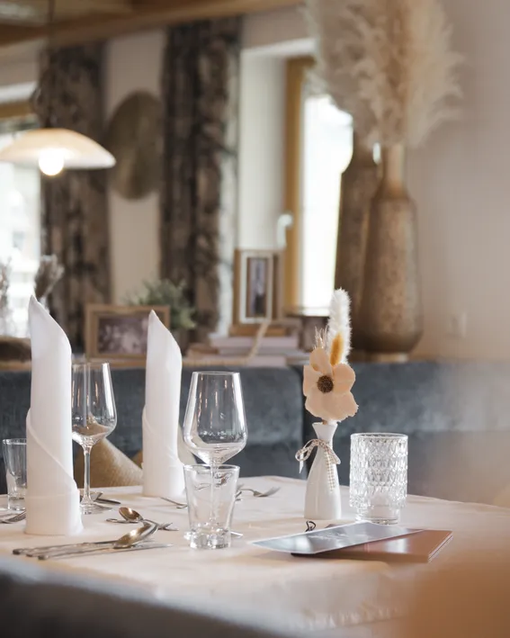 Eleganter Esstisch mit Gläsern, Servietten und Blumendekoration