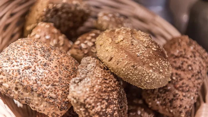 Auswahl an Vollkornbrötchen mit Körnern in einem Korb