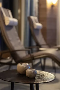 Keramikäpfel auf rundem Tisch im Spa-Ruheraum mit Liegestühlen