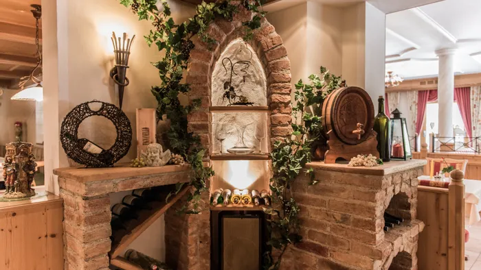 Rustikale Weinecke mit Weinregal, Fässern und Efeudekor im gemütlichen Restaurantinterieur