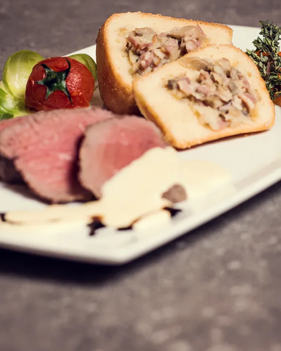 Gourmet plate with sliced roast beef, stuffed pastry, grilled tomato and vegetables
